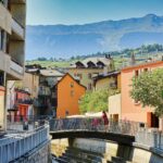 A small bridge over a small river in a city